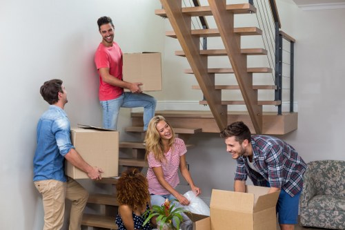 Specialist piano moving team handling an upright piano in Ilford