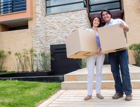 Removal professionals carrying furniture down stairs during an Ilford flat move